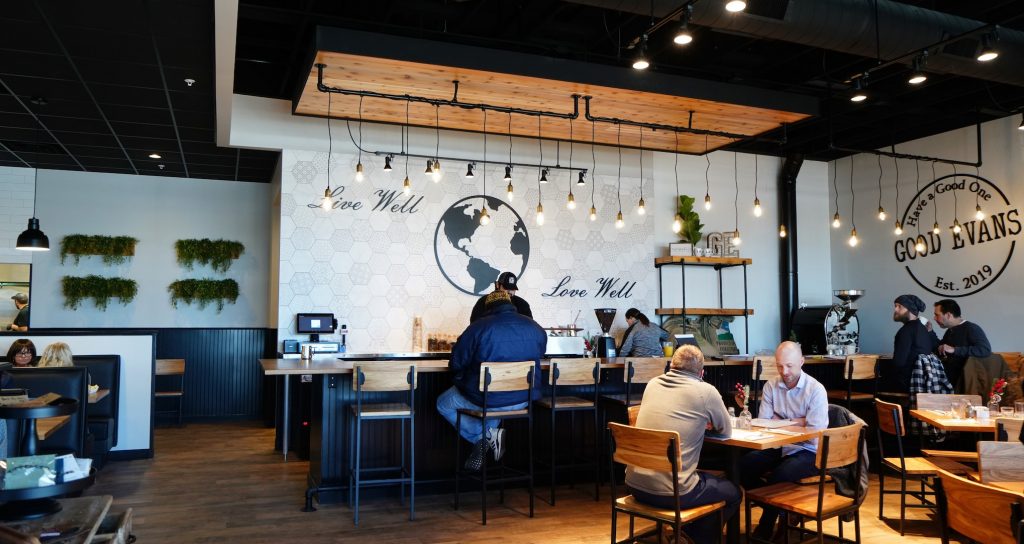 modern tables and seating of Good Evans with hanging lights. 