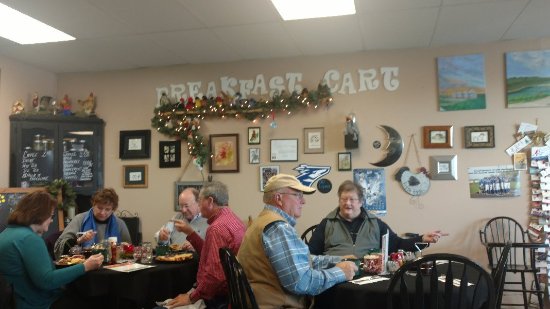 People sitting at tables eating breakfast. 