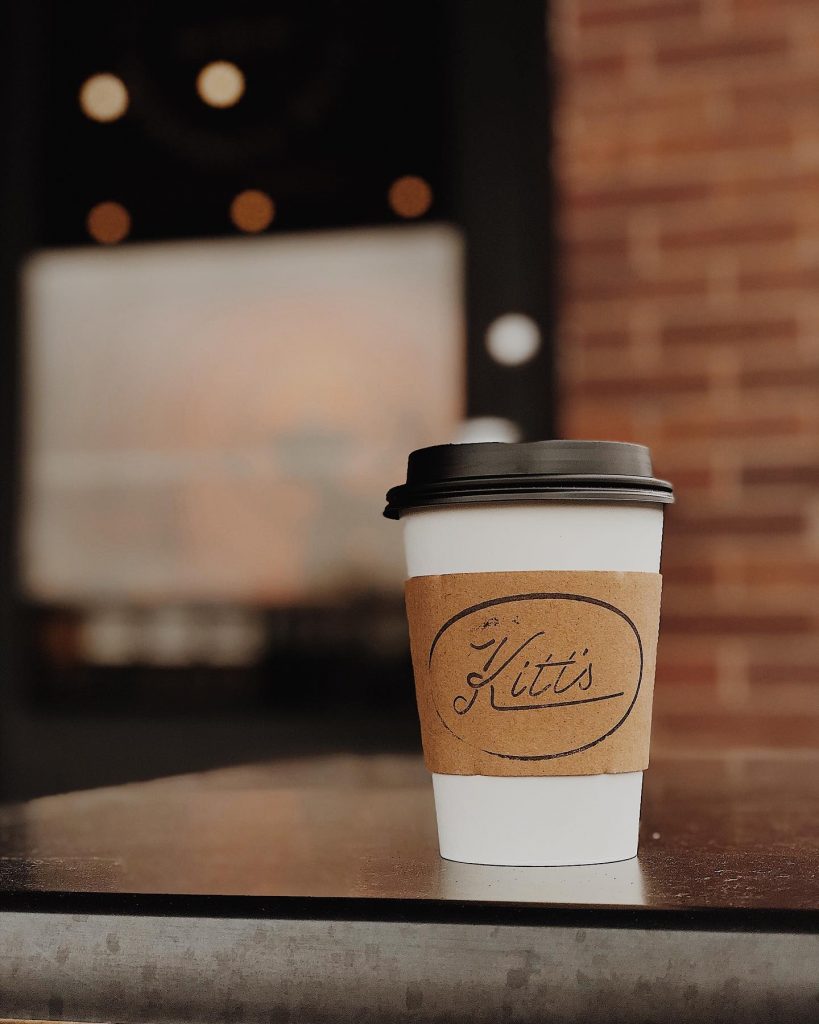 Coffee cup with Kitt's written on coffee sleeve. 