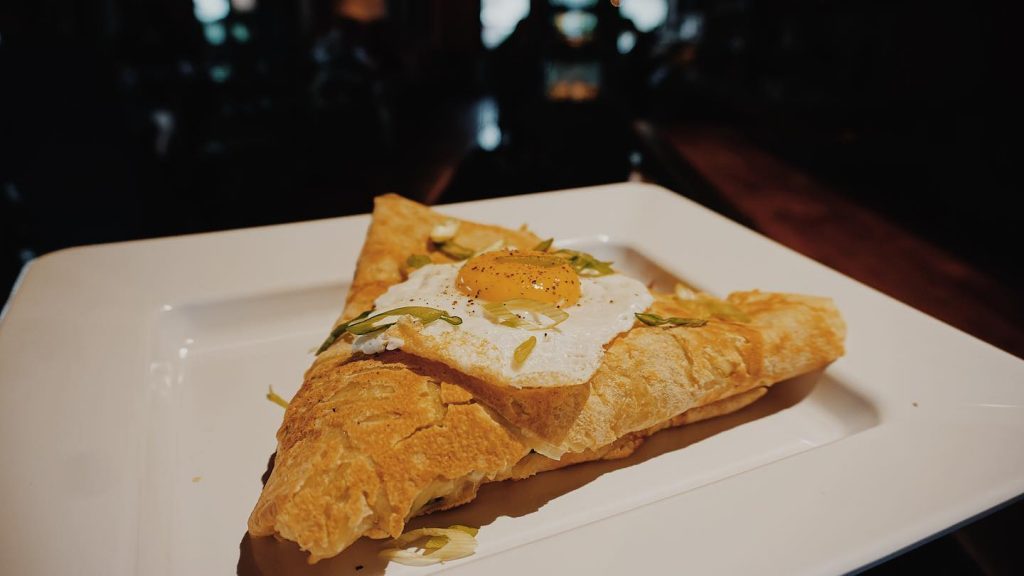 triangle pastry with fried egg on top. 