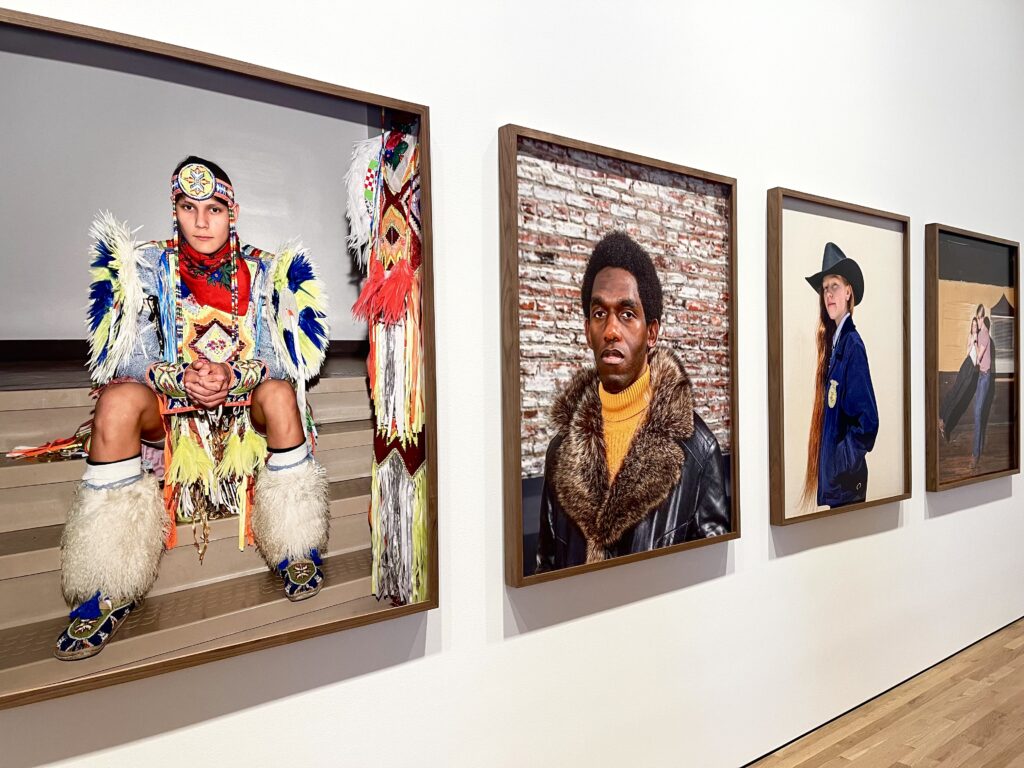 paintings of people from different cultures hanging on the wall.