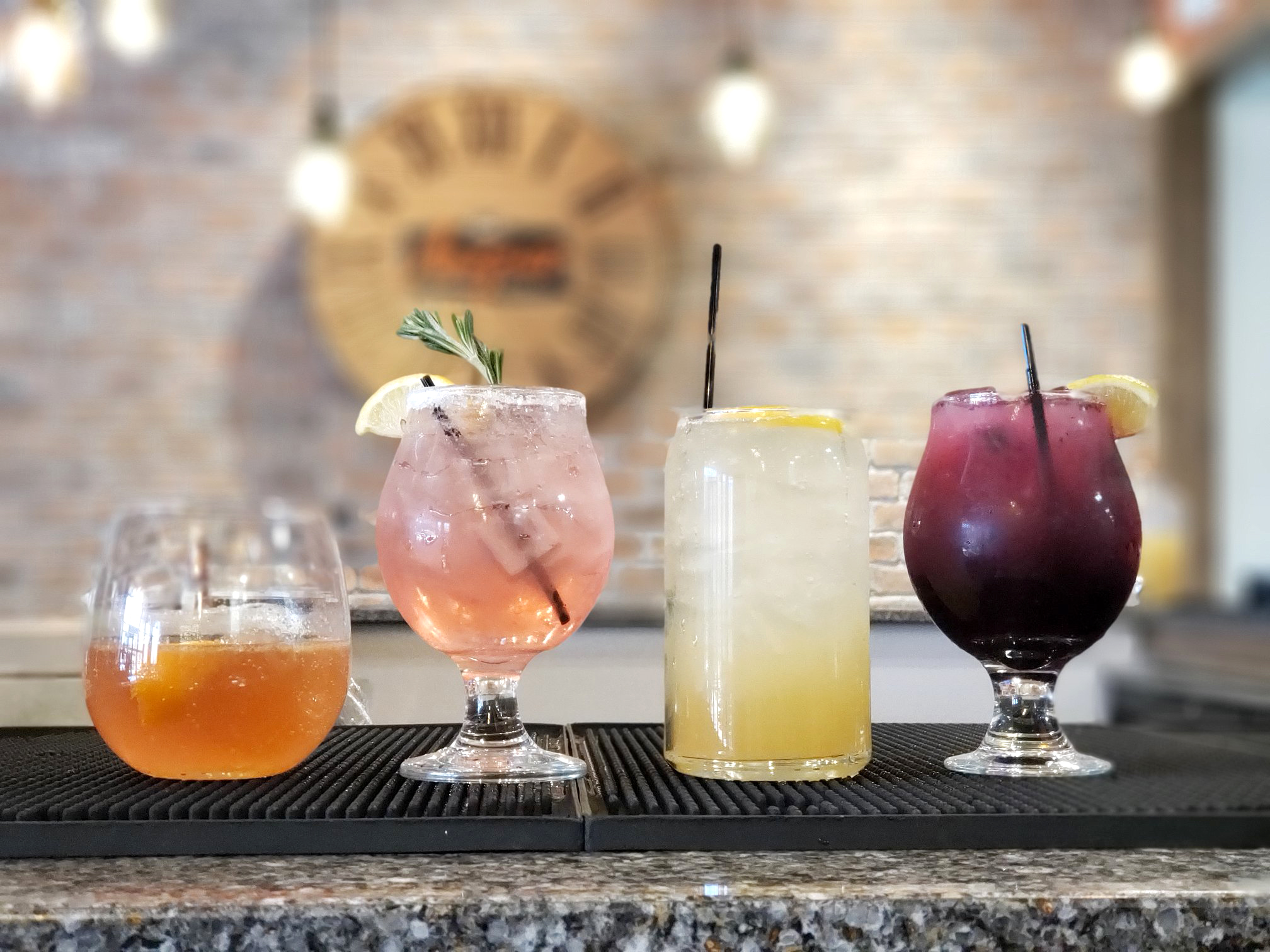 Glasses of colorful cocktails on granite bar counter at Angus burgers and shakes.