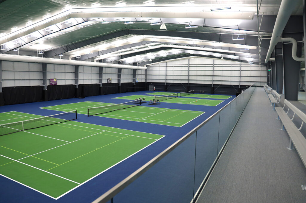 green tennis courts with a raised area for seating and watching. 