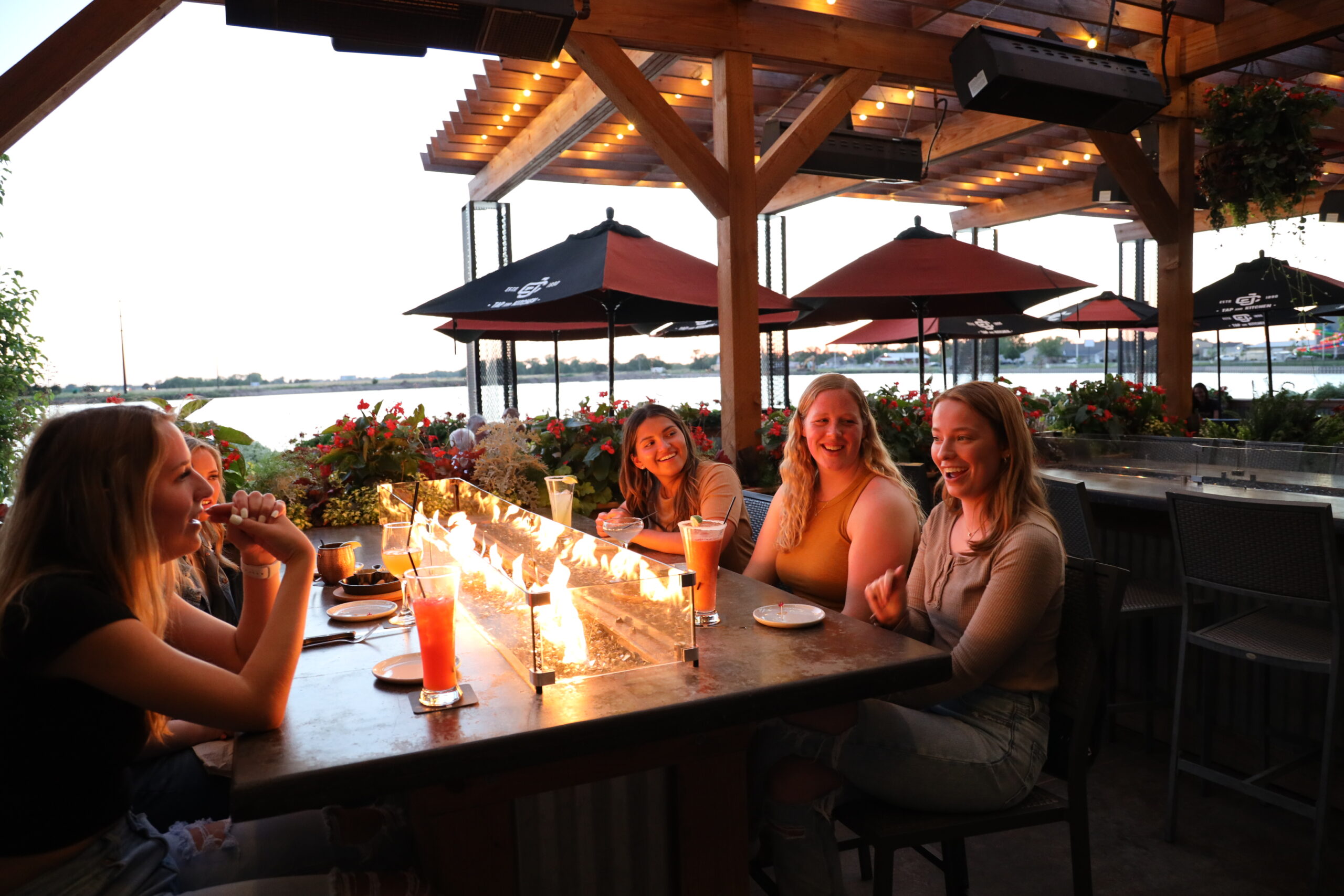 Ladies sitting around patio table with fireplace at Cunningham's restaurant