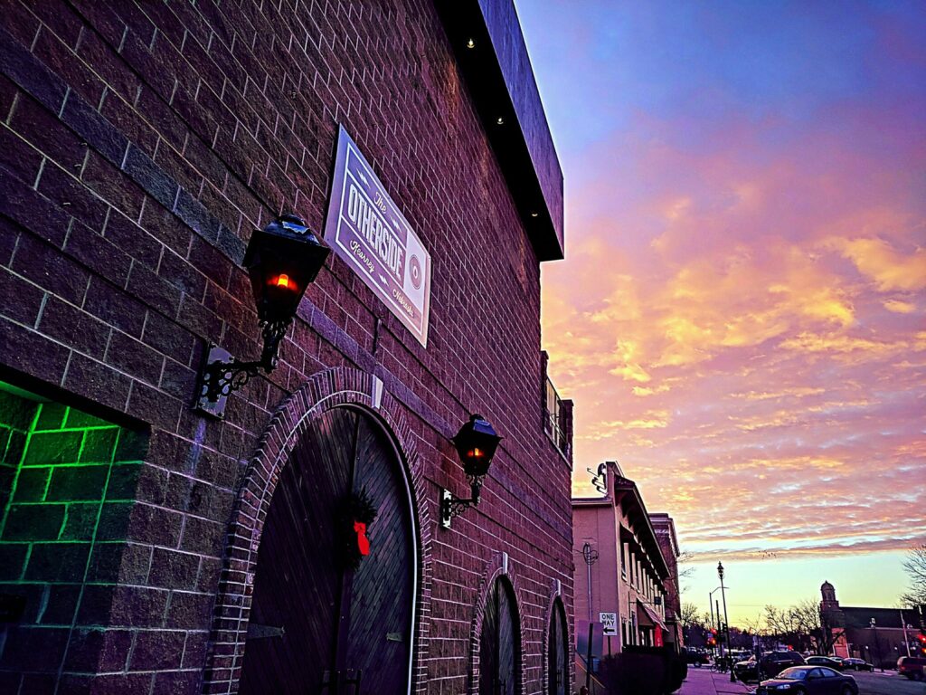 Brick exterior of The Other Side at sunset.