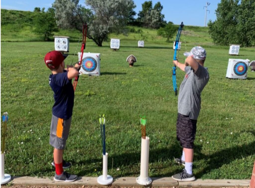 two people pulling back arrows as they aim for the target. 