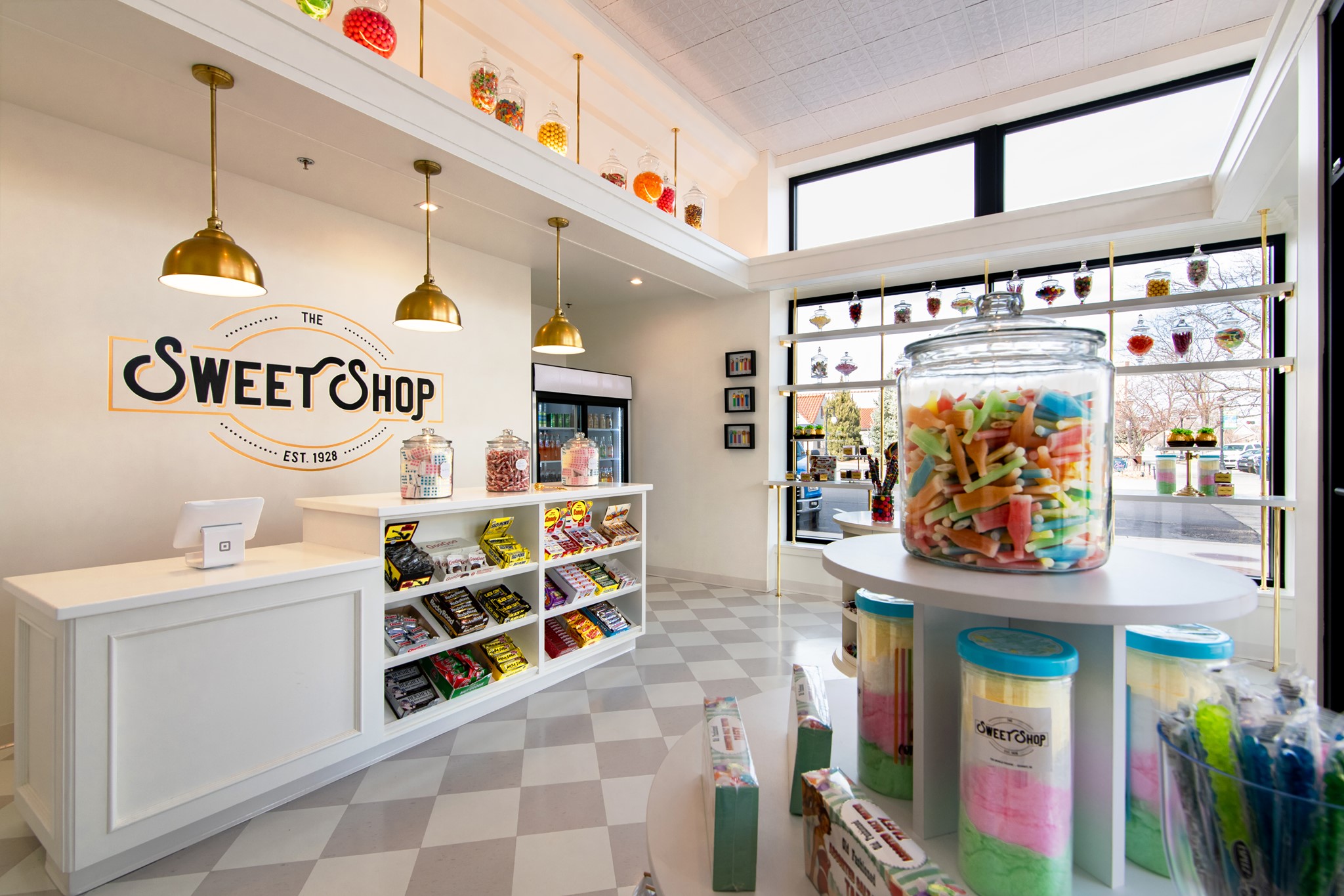 sweet shop shelves lined with jars of various sweets and candies.
