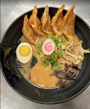 Bowl of soup with fried dumplings and hard boiled egg, topped with green onions, bean sprouts, and seaweed. 
