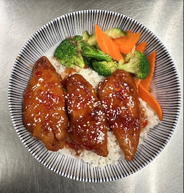 Sesame chicken over white rice with steamed broccoli and carrot slices. 