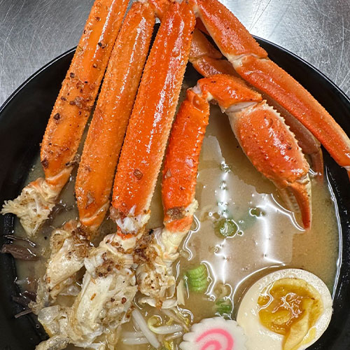 Soup with hard boiled egg and crab legs. 