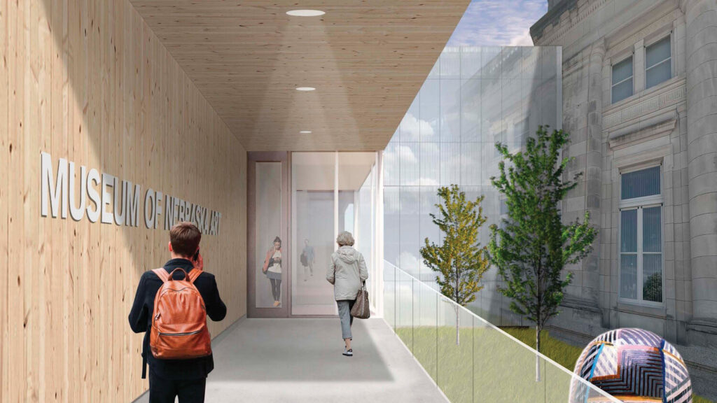 People walking in courtyard between the original building and new addition. 