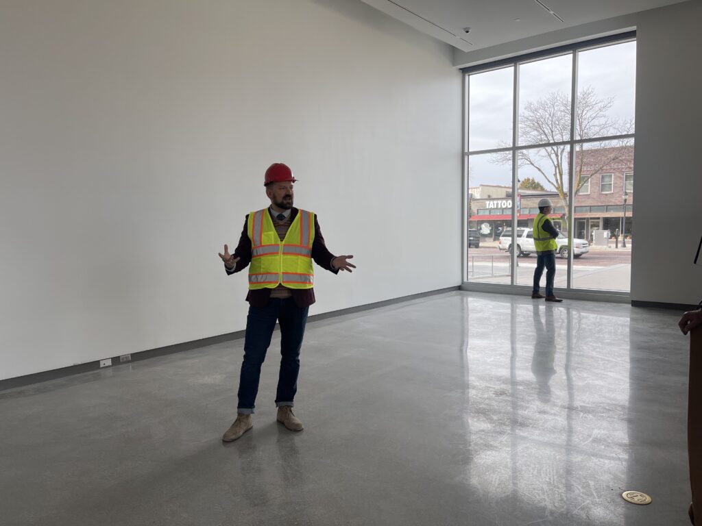 Workers in construction vests examining the building of the museum. 