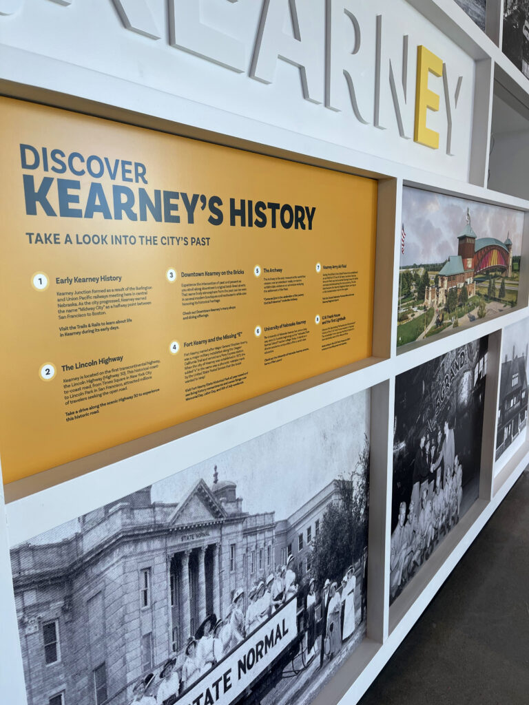 Wall displaying photos of to Discover Kearney's History with descriptions. 