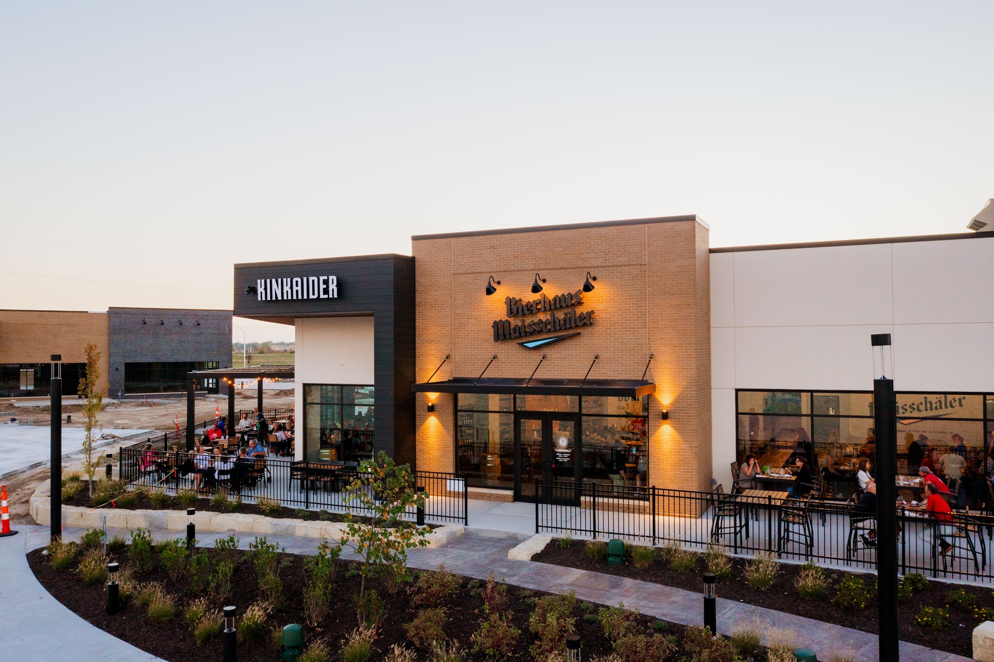 exterior view of Bierhaus Maisschaler restaurant with people in the outdoor seating. 