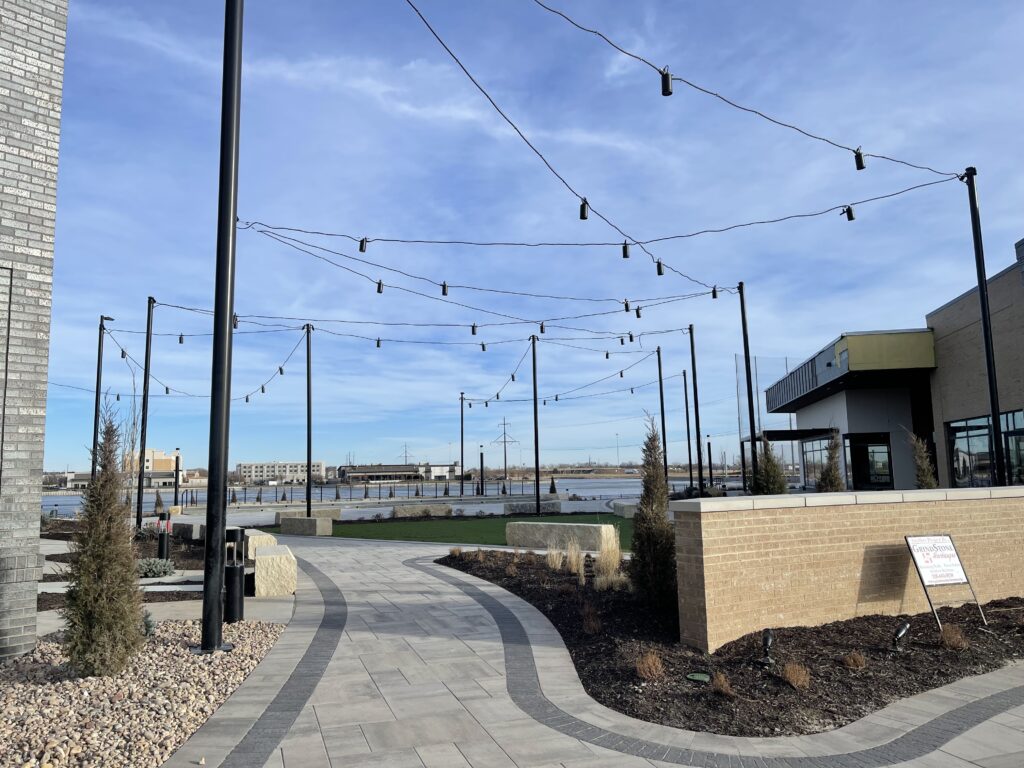 outdoor seating and walkway with string lights between restaurants. 