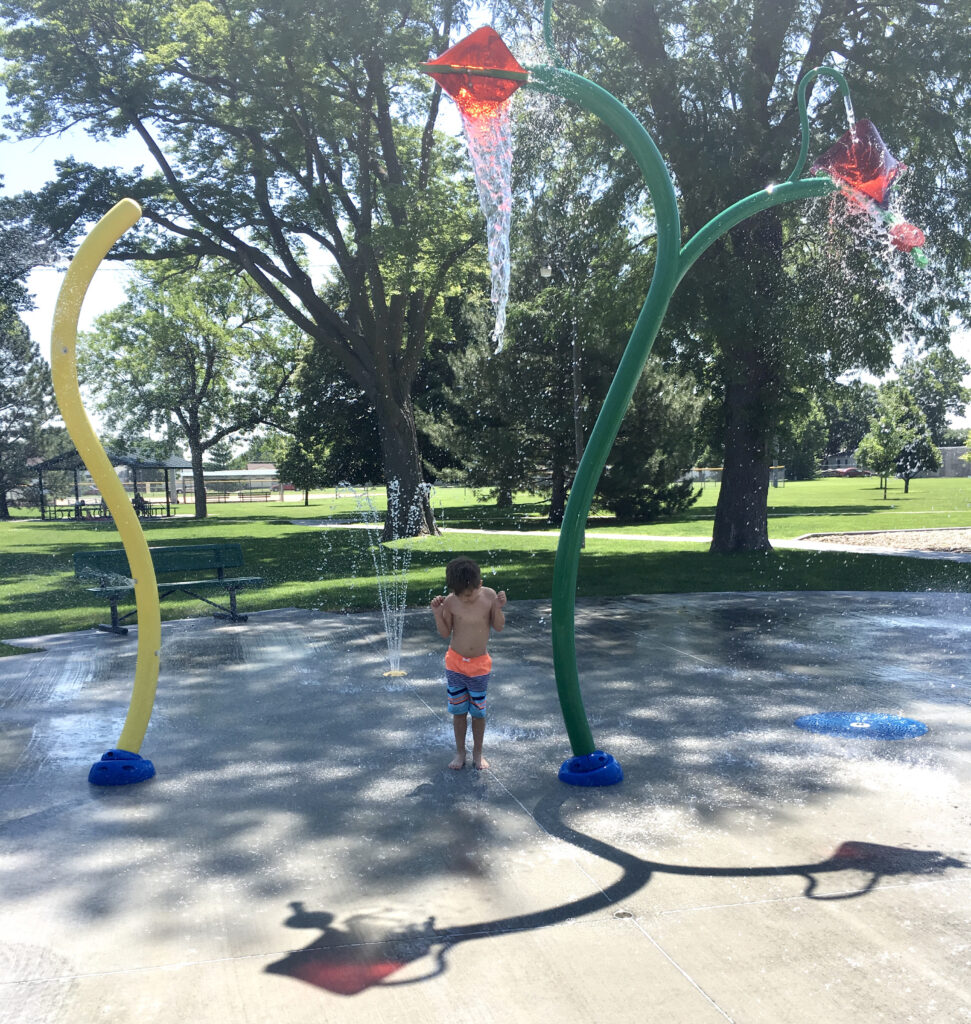 Child waiting under water bucket spray at Dryden Park.